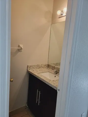 a bathroom with a granite countertop sink and a mirror