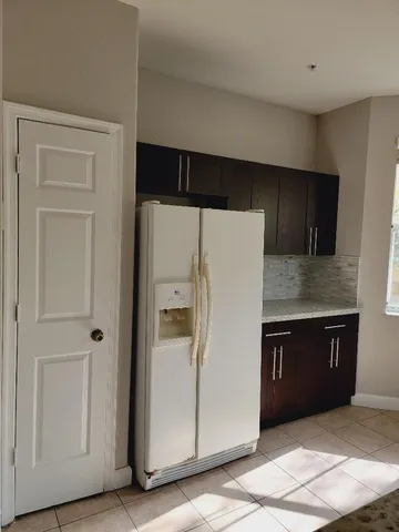 a kitchen with a refrigerator and cabinets