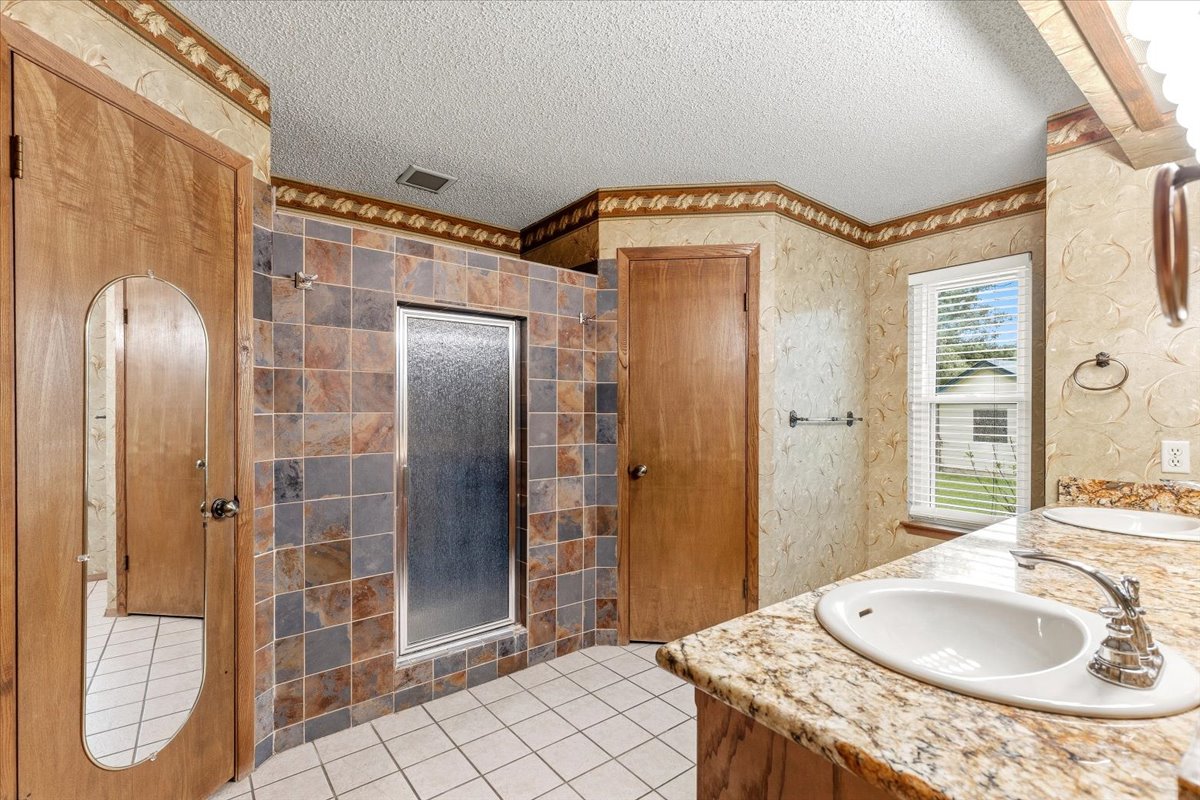 250 Hickory Drive Elgin, TX 78621 - Photo 17 of 37 a bathroom with a granite countertop sink a mirror and shower