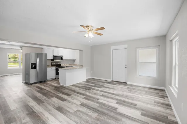 a view of kitchen with faucet cabinets and refrigerator