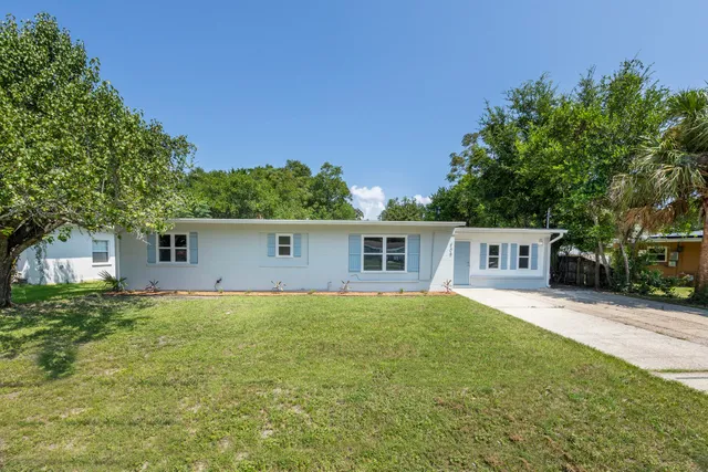 a front view of house with yard and trees