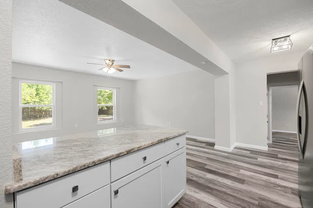 a bathroom with a granite countertop sink and a window
