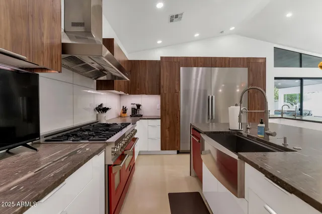 a kitchen with granite countertop a sink stove and refrigerator
