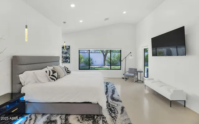 a bedroom with a bed and large window