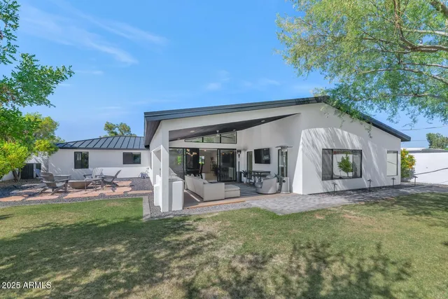 a view of a house with backyard porch and sitting area