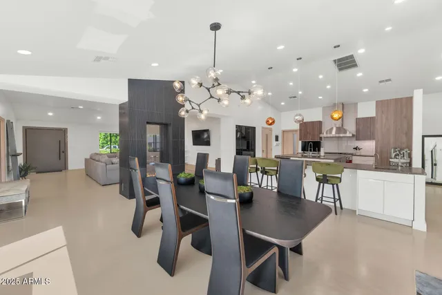 a kitchen with a refrigerator and chairs