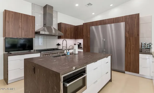 a kitchen with stainless steel appliances granite countertop a sink a microwave a refrigerator and a stove