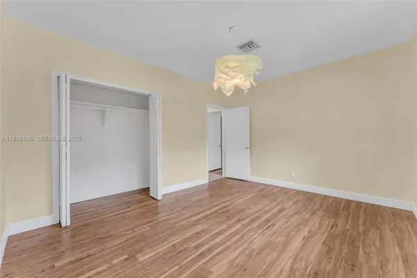 a bedroom with a bed a couch and a chandelier