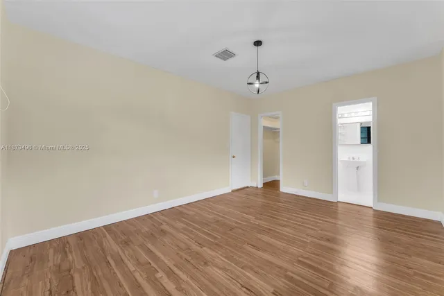a view of empty room with wooden floor and ceiling fan