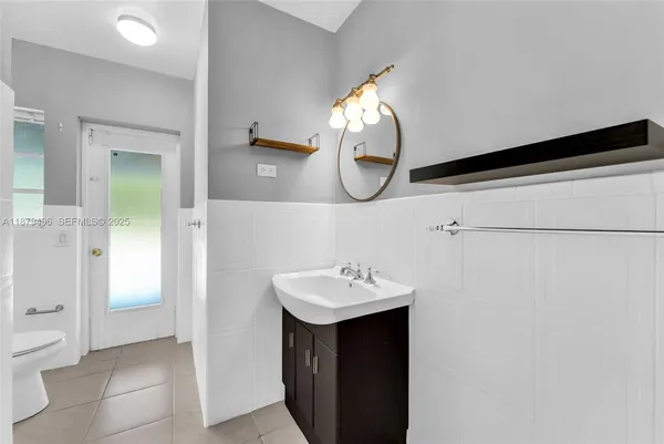 an empty room with wooden floor and fan