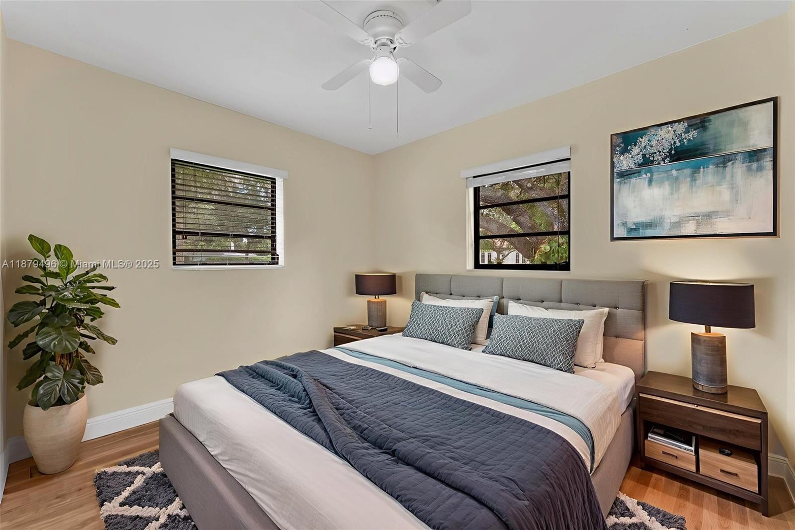 6275 Southwest 123rd Terrace Pinecrest, FL 33156 - Photo 30 of 49 a bedroom with a bed a painting on the wall and a potted plant