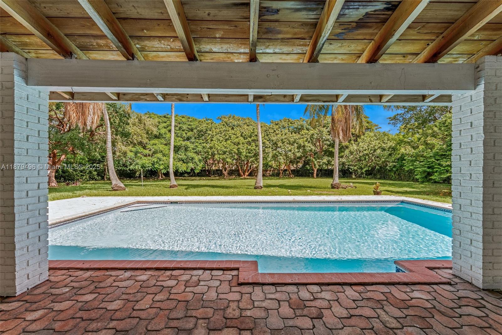 6275 Southwest 123rd Terrace Pinecrest, FL 33156 - Photo 4 of 49 a view of a swimming pool with a yard