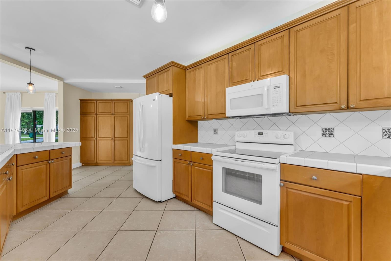 6275 Southwest 123rd Terrace Pinecrest, FL 33156 - Photo 6 of 49 a kitchen with a refrigerator sink stove and cabinets
