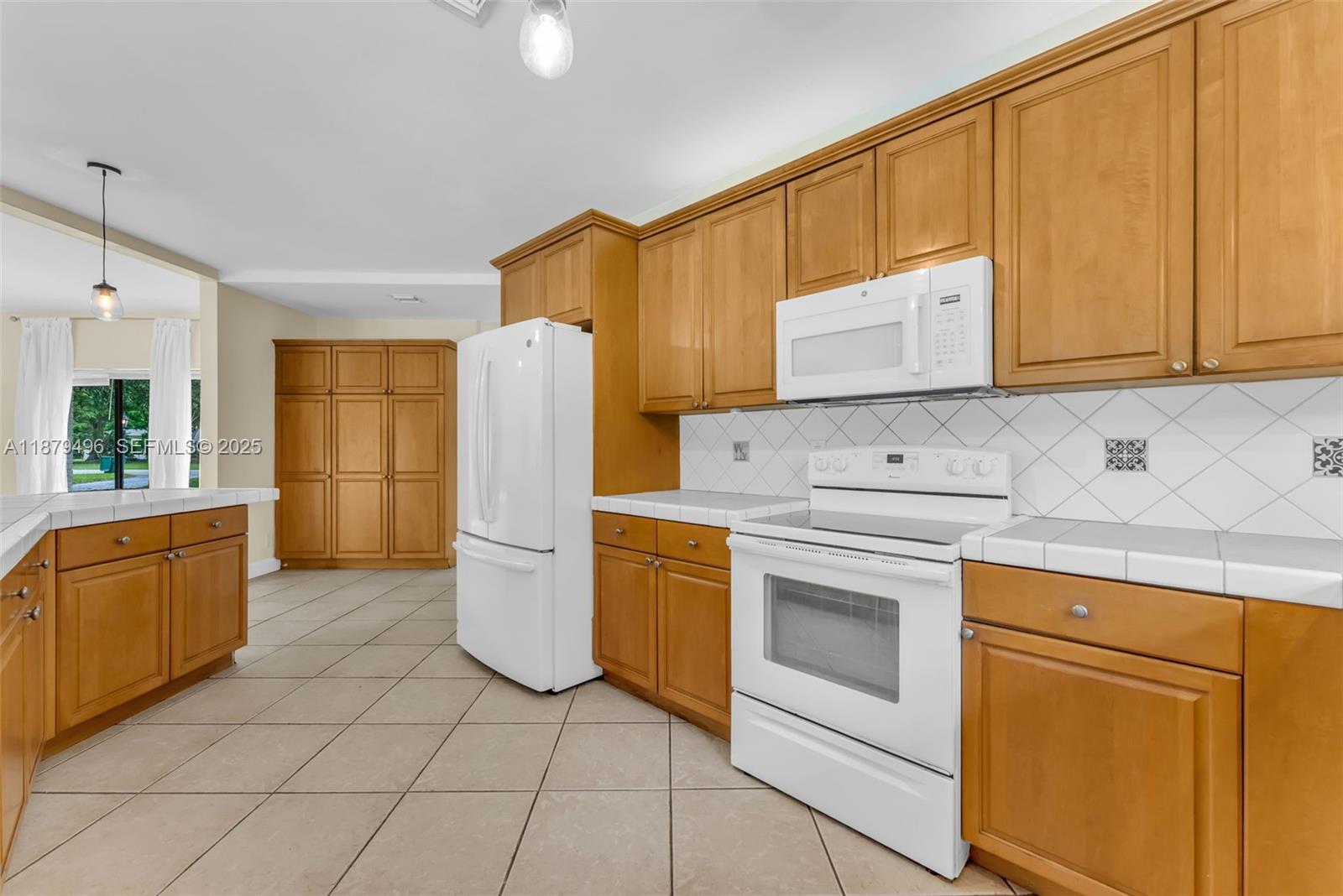 6275 Southwest 123rd Terrace Pinecrest, FL 33156 - Photo 6 of 49 a kitchen with a refrigerator sink stove and cabinets