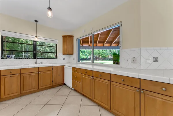 a large white kitchen with stainless steel appliances granite countertop a sink and cabinets