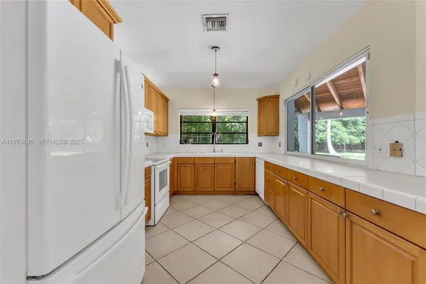 a large white kitchen with sink and window