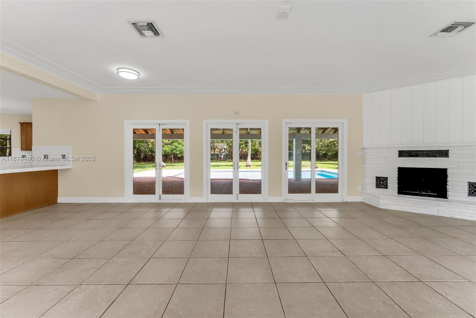 6275 Southwest 123rd Terrace Pinecrest, FL 33156 - Photo 10 of 49 a view of an empty room with a fireplace and a window