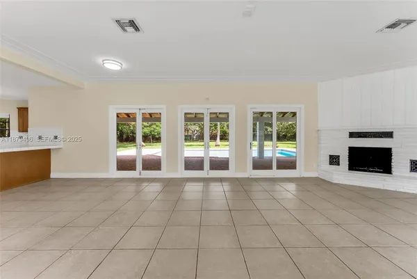 a view of an empty room with a fireplace and a window