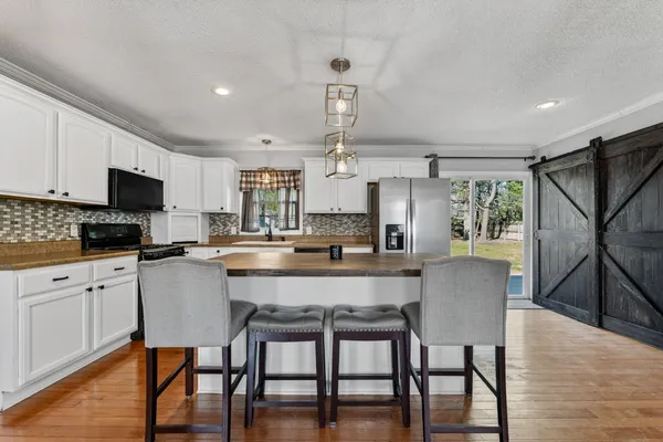 a kitchen with a table chairs refrigerator and microwave
