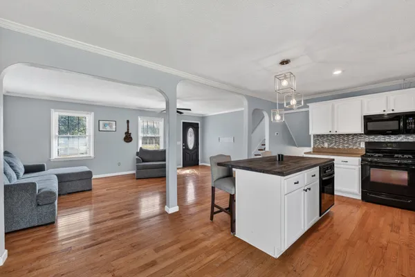 a kitchen with stainless steel appliances granite countertop wooden floors and stove
