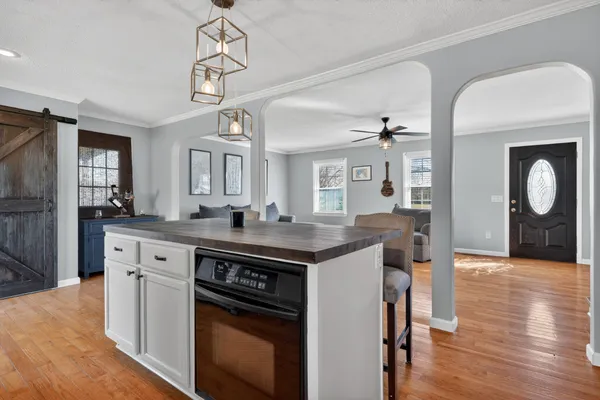 a kitchen with a stove and wooden floor
