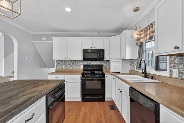 a kitchen with a sink stove and microwave