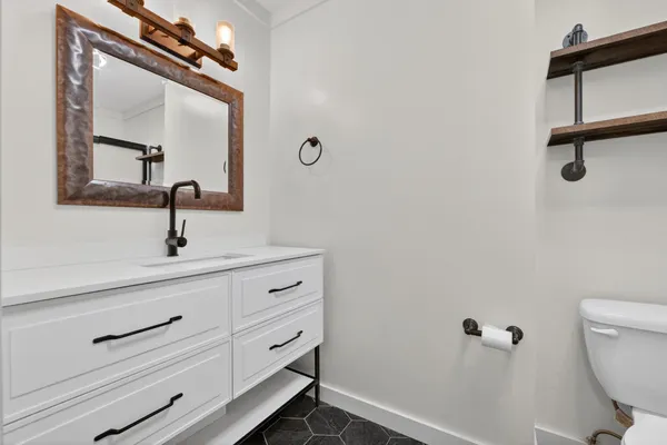 a bathroom with a sink a toilet and mirror
