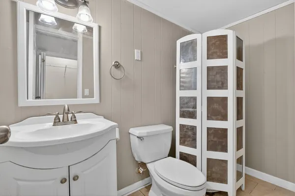 a bathroom with a toilet a sink and a mirror