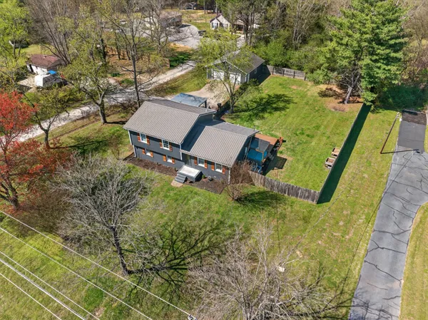 an aerial view of a house with a yard and trees