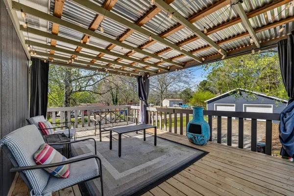 a view of a patio with table and chairs with wooden floor and fence
