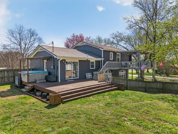 a view of a house with a big yard and wooden fence