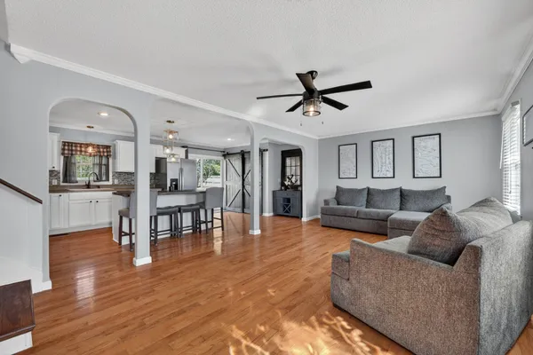 a living room with furniture and a view of kitchen
