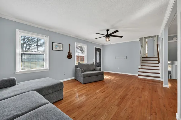 a living room with furniture and a hard wood floor