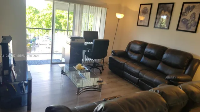 a living room with furniture and a floor to ceiling window