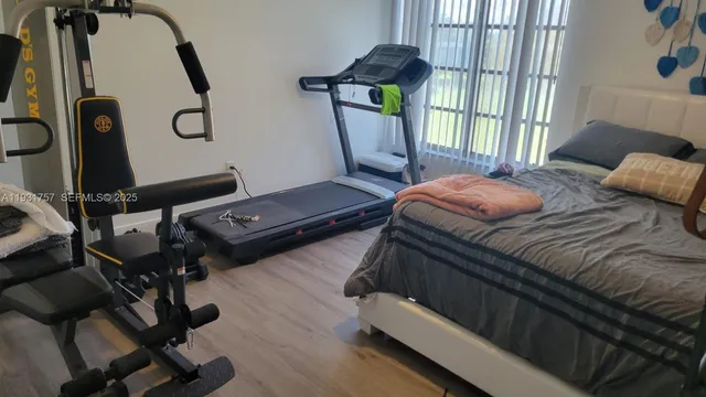 a bedroom with a bed and large windows