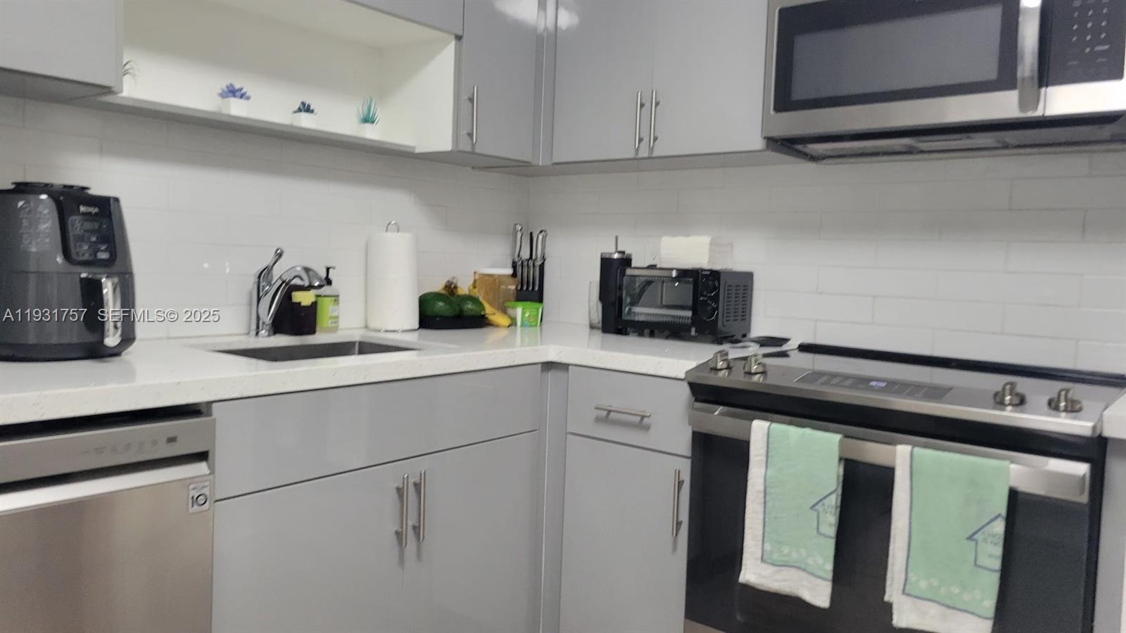 4158 Inverrary Drive, Unit 409 Lauderhill, FL 33319 - Photo 4 of 23 a kitchen with appliances cabinets and a counter top space