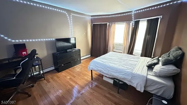 a bedroom with a bed chandelier and a window