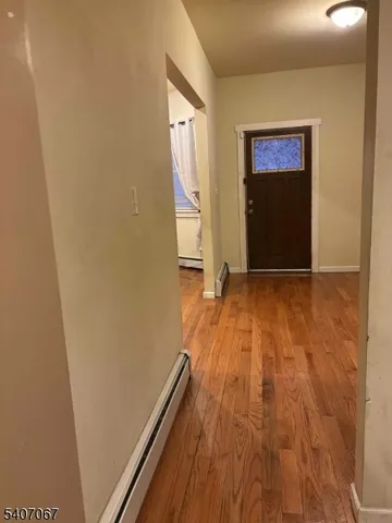 a view of an empty room with wooden floor