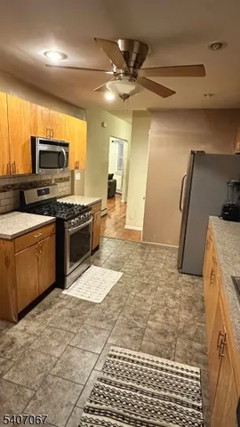 a kitchen with stainless steel appliances granite countertop a stove top oven a sink a counter space and cabinets