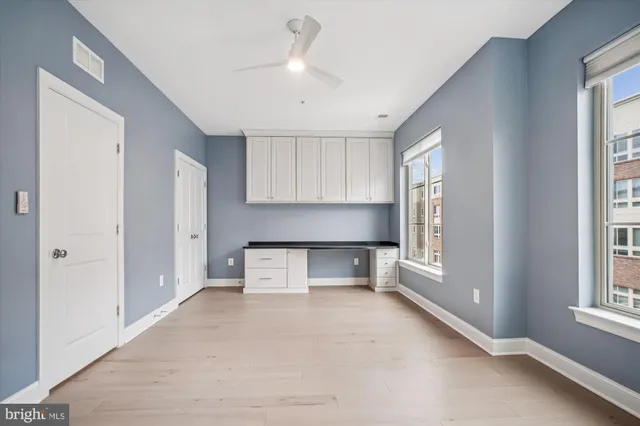 a large white kitchen with white cabinets and a window