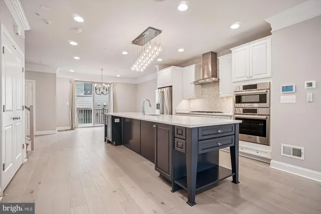 a kitchen with stainless steel appliances kitchen island granite countertop a table and chairs in it