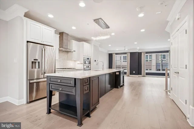 a large kitchen with stainless steel appliances lots of counter space and wooden floor