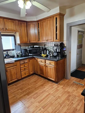 a kitchen with stainless steel appliances granite countertop a sink cabinets and wooden floor