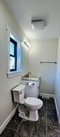 31 Niagara Street Fall River, MA 02721 - Photo 7 of 19 a bathroom with a granite countertop toilet a sink and a mirror