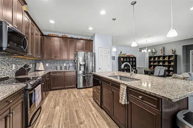 a kitchen with stainless steel appliances granite countertop a stove sink microwave and refrigerator