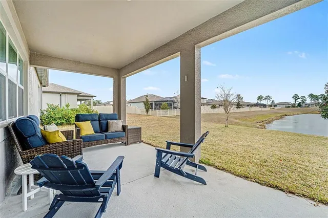 a living room with furniture and floor to ceiling window