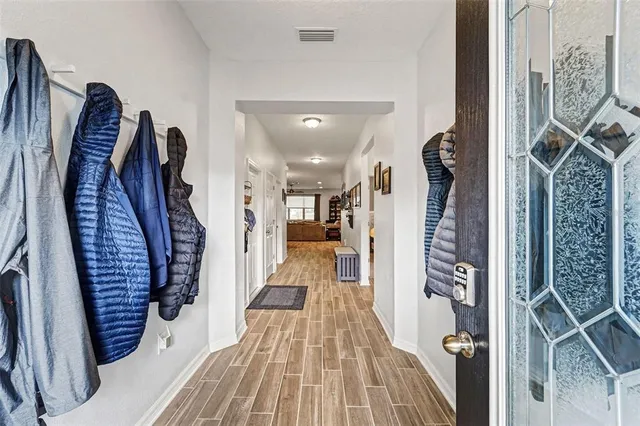 a view of a hallway with wooden floor and stairs