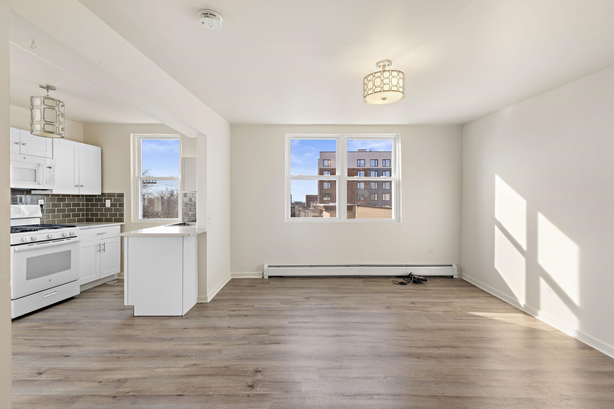 201 16th Street, Unit 3 Union City, NJ 07087 - Photo 2 of 8 a view of a kitchen with wooden floor and a sink