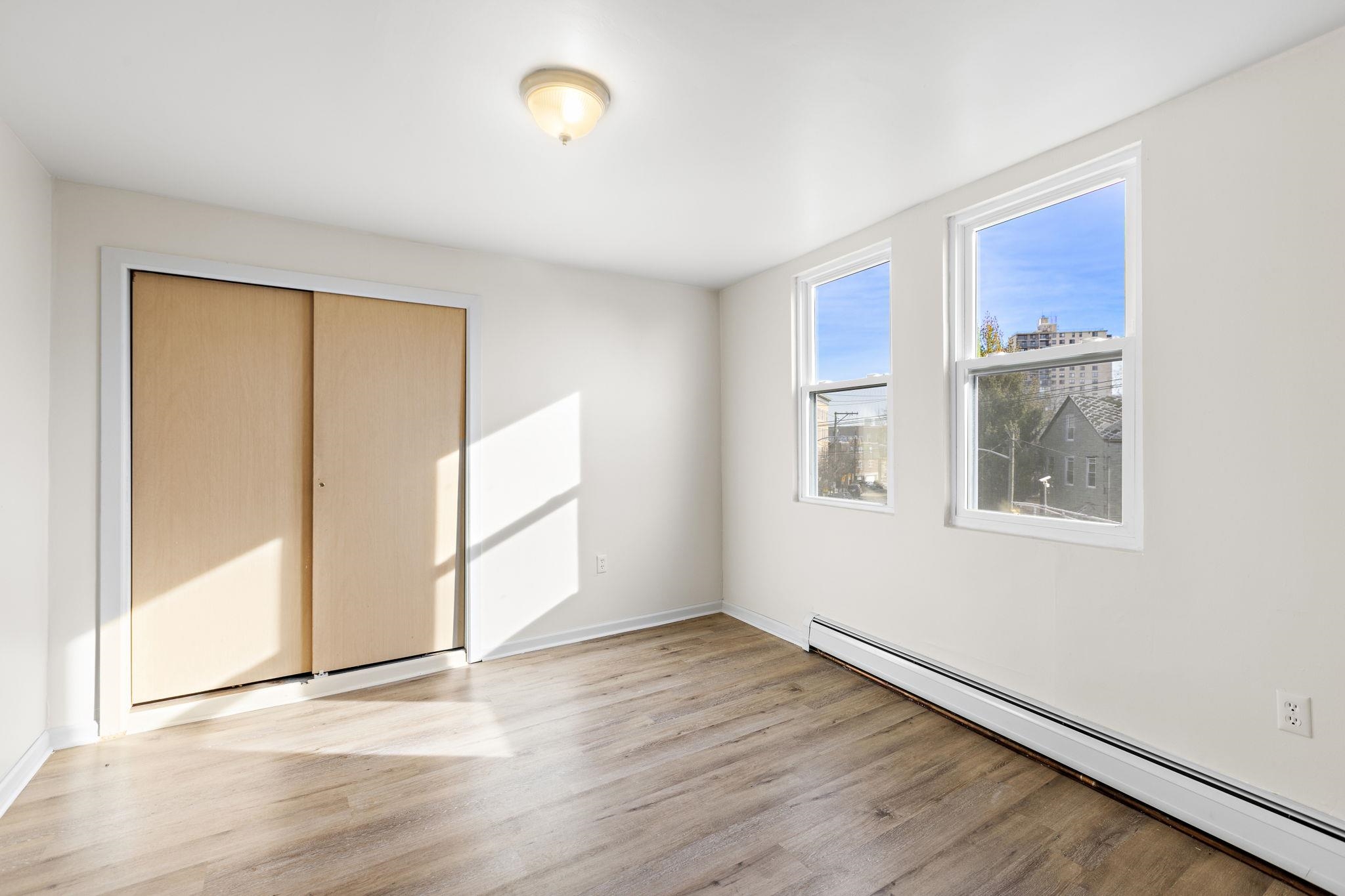 201 16th Street, Unit 3 Union City, NJ 07087 - Photo 4 of 8 a view of an empty room with wooden floor and a window