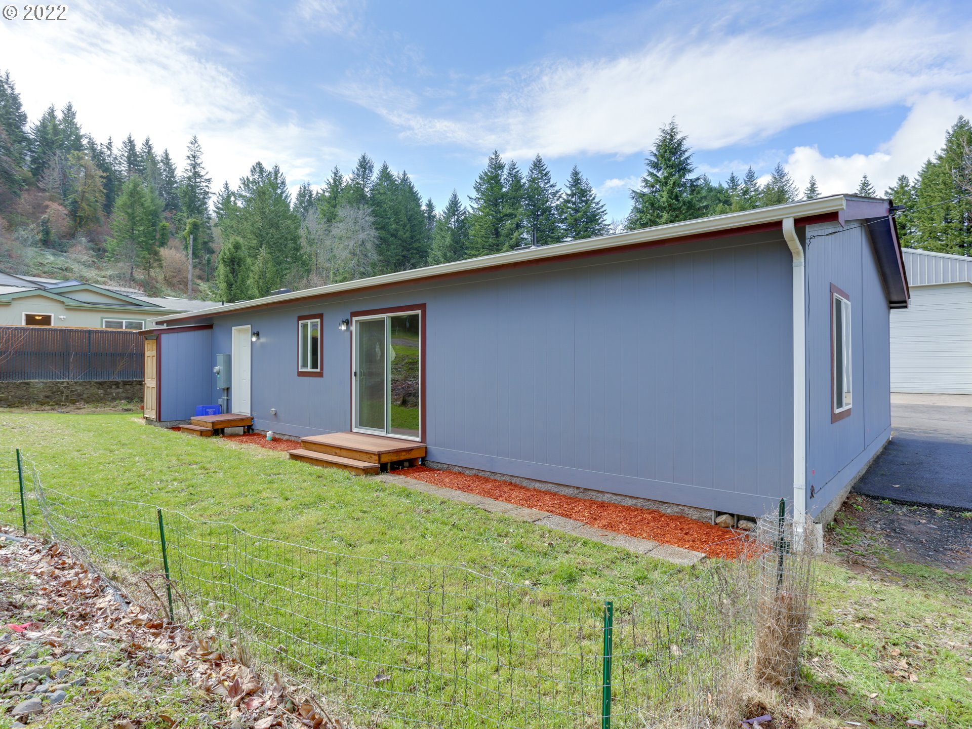 48 Southwest Ruckel Street Cascade Locks, OR 97014 - Photo 27 of 27 a backyard of a house with wooden floor and outdoor seating